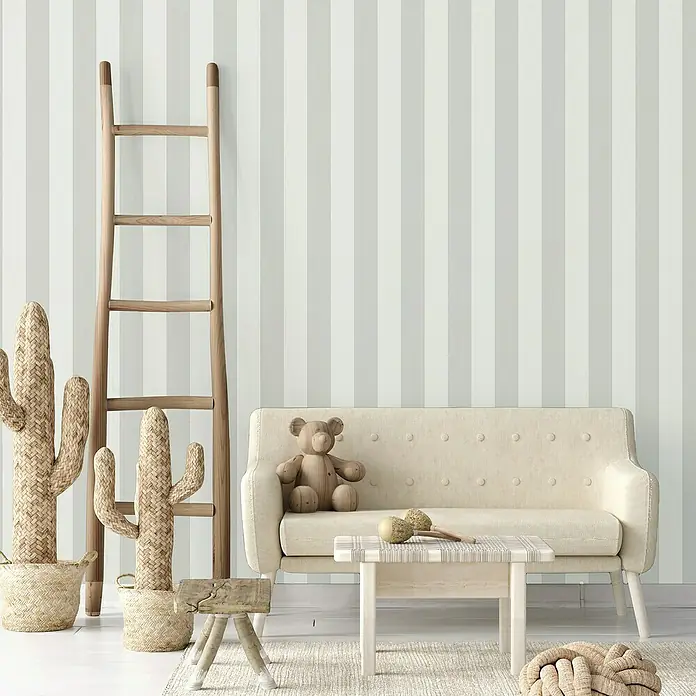 A.S. Création Trendwall 2 Vliestapete - Grau/Weiß, Streifen, 10,05 x 0,53 m - Einladendes Kinderzimmer mit gestreifter Tapete, Leiter, Kaktus, Teddybär und kleinem Sofa, das Wärme und Stil vereint.