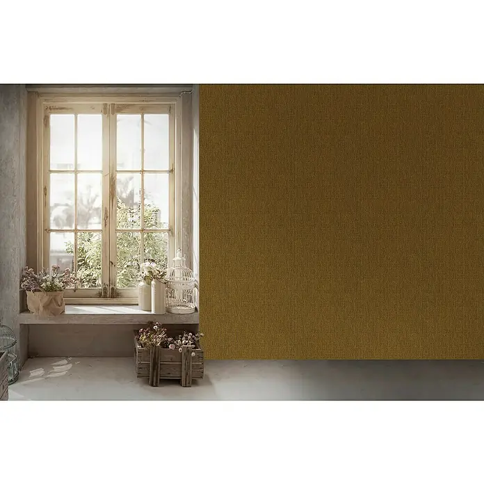 A.S. Création Hygge 2 Vliestapete Bambusstruktur - Gelb/Gold, Uni, 10,05 x 0,53 m - Rustikales Interieur mit Fenster, Blumen und Vogelkäfig. Die Szene vermittelt eine gemütliche Atmosphäre. Wand im Hintergrund in ockerfarbenem Stoff.