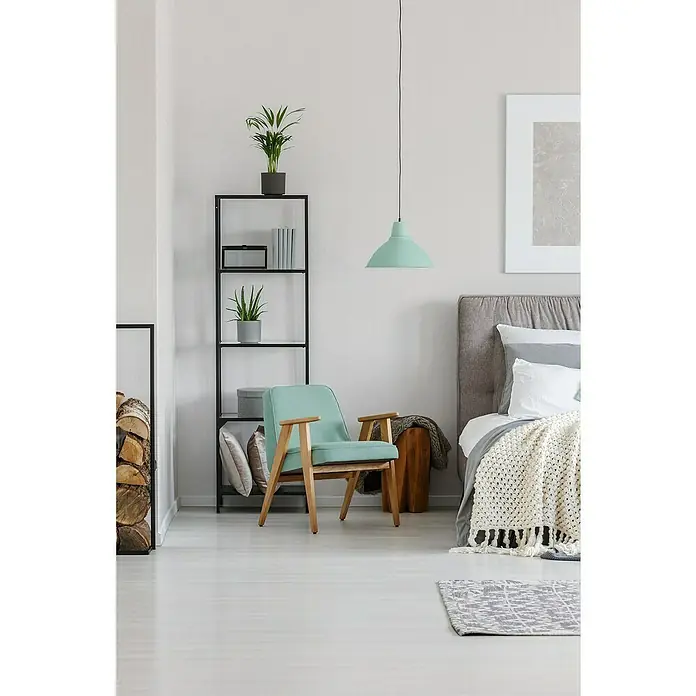 A.S. Création Attractive Vliestapete - Schmeichelndes Weiß, Uni, 10,05 x 0,53 m - Zimmerinterieur mit mintgrünem Sessel im Fokus, ergänzt durch ein Regal, eine Hängelampe und dekorative Elemente für eine stilvolle Atmosphäre.
