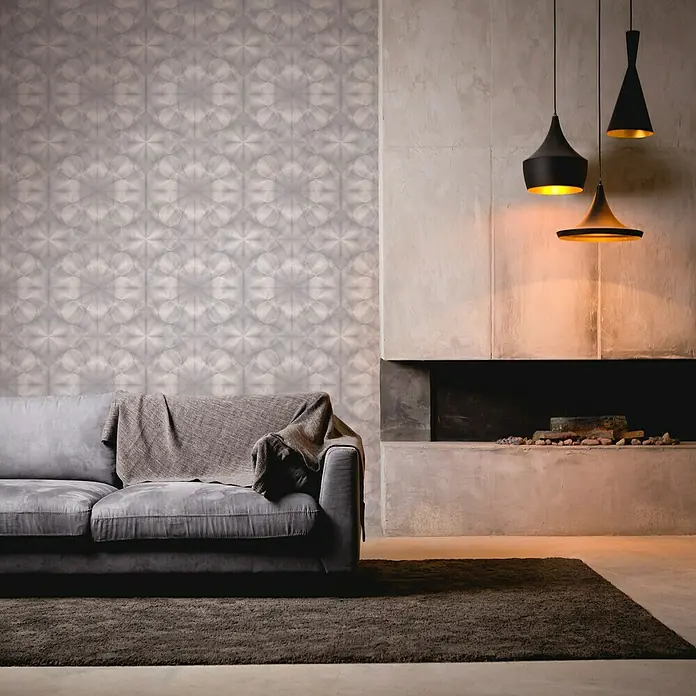 A.S. Création My Home My Spa Vliestapete Hologramm - Grau, 3D-Optik, 10,05 x 0,53 m - Wohnzimmer mit grauem Sofa, Teppich und stilvollen Pendelleuchten über einem modernen Kamin, akzentuiert durch gemusterte Tapete.