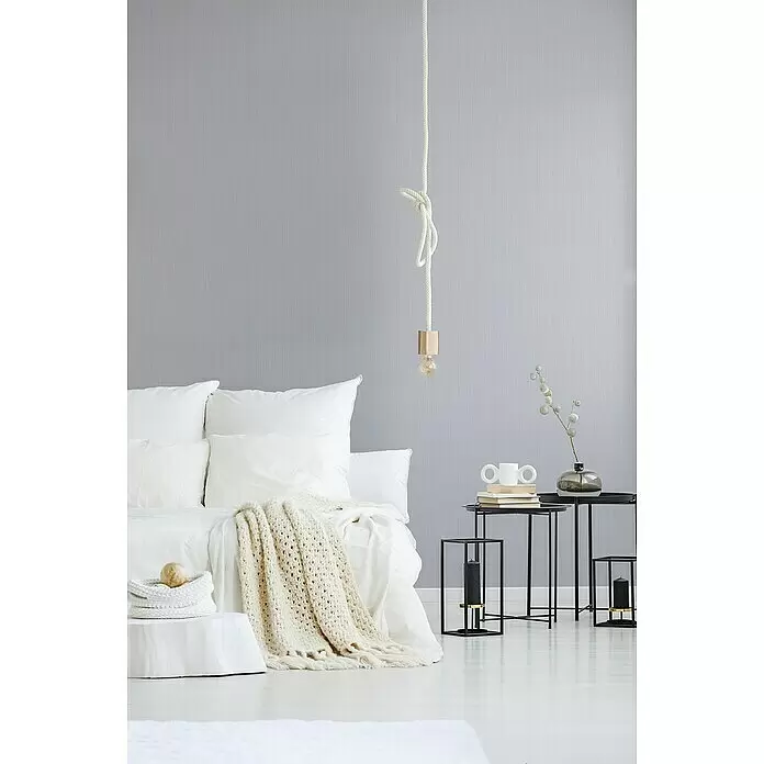 A.S. Création Attractive Vliestapete - Strukturgrau, Uni, 10,05 x 0,53 m - Minimalistisches Schlafzimmer mit weißem Bett, beigem Stricküberwurf und schwarzen Metall-Beistelltischen.