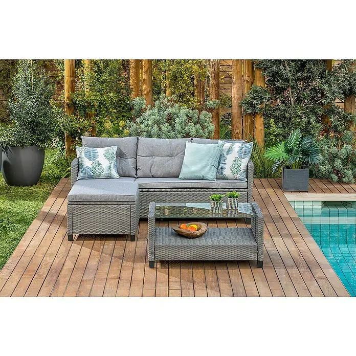 Conjunto de muebles Mora - 3 pzs., Ratán sintético, Gris - Conjunto de muebles de jardín gris con sofá, mesa y cojines en una terraza de madera junto a una piscina, ideal para relajarse al aire libre.