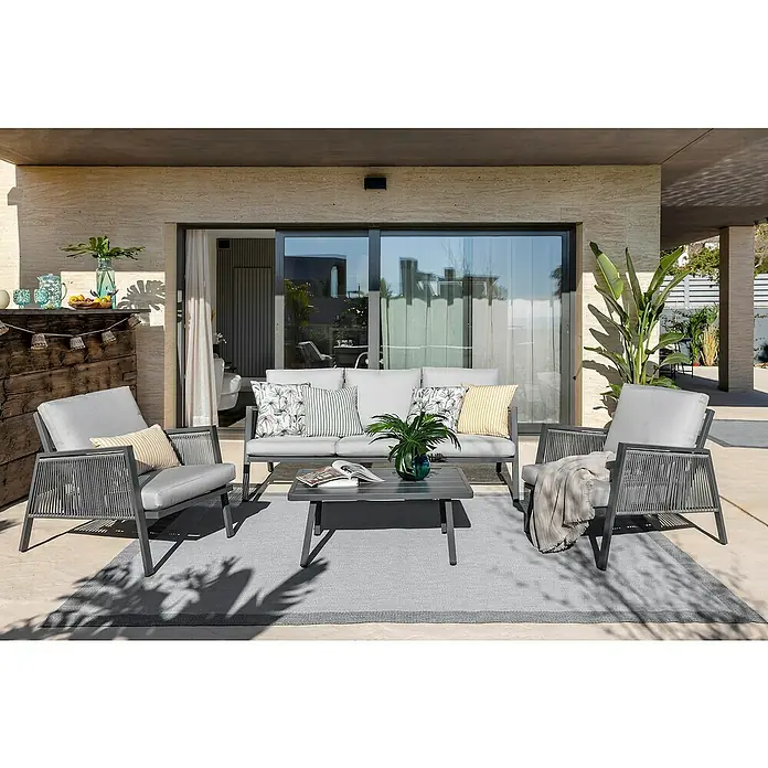 Sunfun Conjunto de muebles Keira - 4 pzs., Aluminio, Antracita - Un moderno conjunto de muebles de exterior con sofá gris, sillones y mesa sobre una alfombra para un oasis elegante.