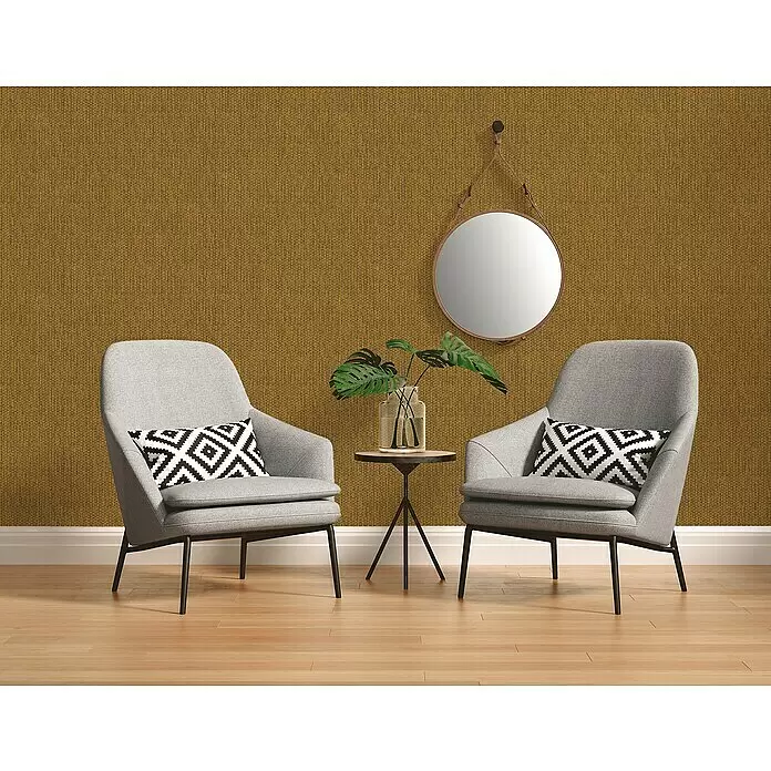 A.S. Création Hygge 2 Vliestapete Bambusstruktur - Gelb/Gold, Uni, 10,05 x 0,53 m - Strukturierte goldbraune Tapete als warmer Hintergrund für zwei moderne graue Sessel.