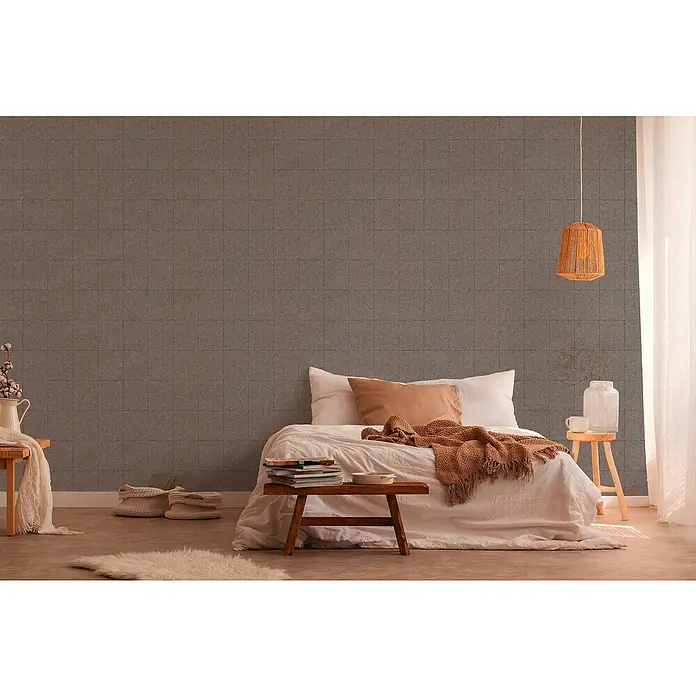 A.S. Création Desert Lodge Vliestapete Krakelee-Fliese - Braun, Fliesenoptik, 10,05 x 0,53 m - Schlafzimmer-Interieur mit Textiltapete in Grau, einladendem Bett und Holzelementen für eine warme Atmosphäre.