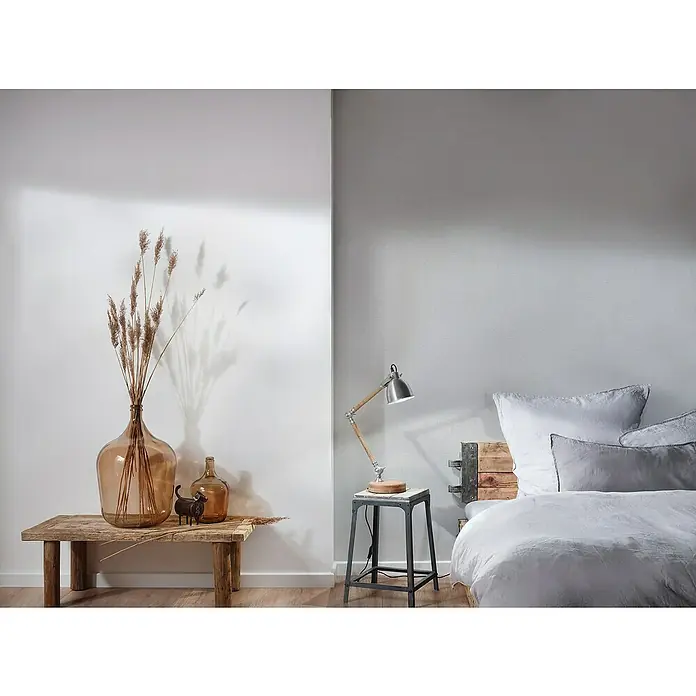 A.S. Création Attractive Vliestapete - Weiches Grau, Uni, 10,05 x 0,53 m - Diese Aufnahme zeigt eine stimmungsvolle Inneneinrichtung mit einer Lampe, rustikalen Möbeln und Deko-Elementen, die eine gemütliche Atmosphäre schaffen.