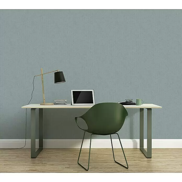 A.S. Création Titanium 3 Vliestapete - Pastellblau, Uni, 10,05 x 0,53 m - Strukturierte blaugrüne Wandverkleidung hinter einem Home-Office-Schreibtisch mit Laptop und Stuhl.
