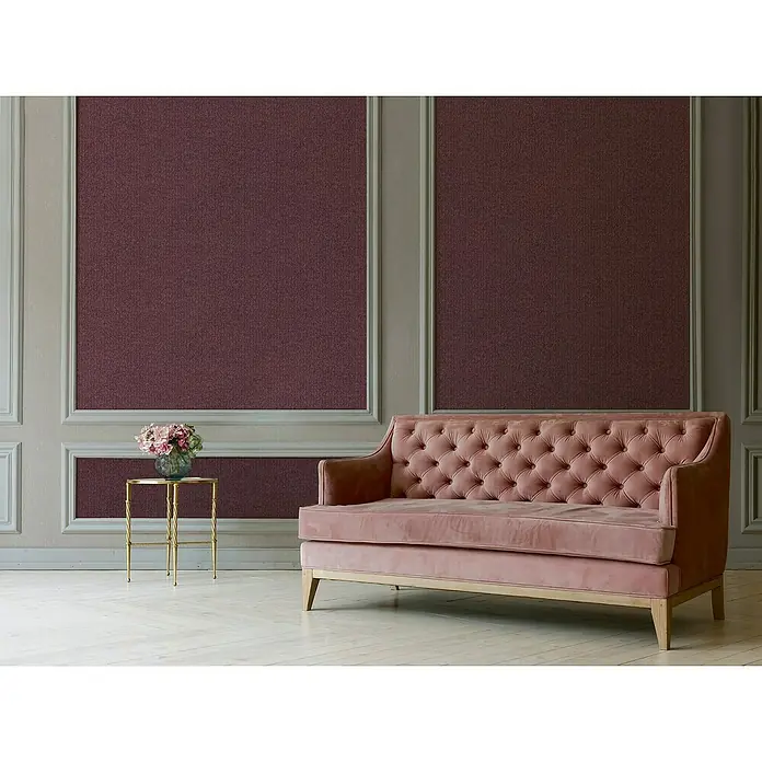 A.S. Création Mata Hari Vliestapete Kleinmuster - Rot, Uni, 10,05 x 0,53 m - Ein rosa Samtsofa mit Knopfheftung steht in einem eleganten Raum. Das Sofa ist das zentrale Element und strahlt Komfort aus.