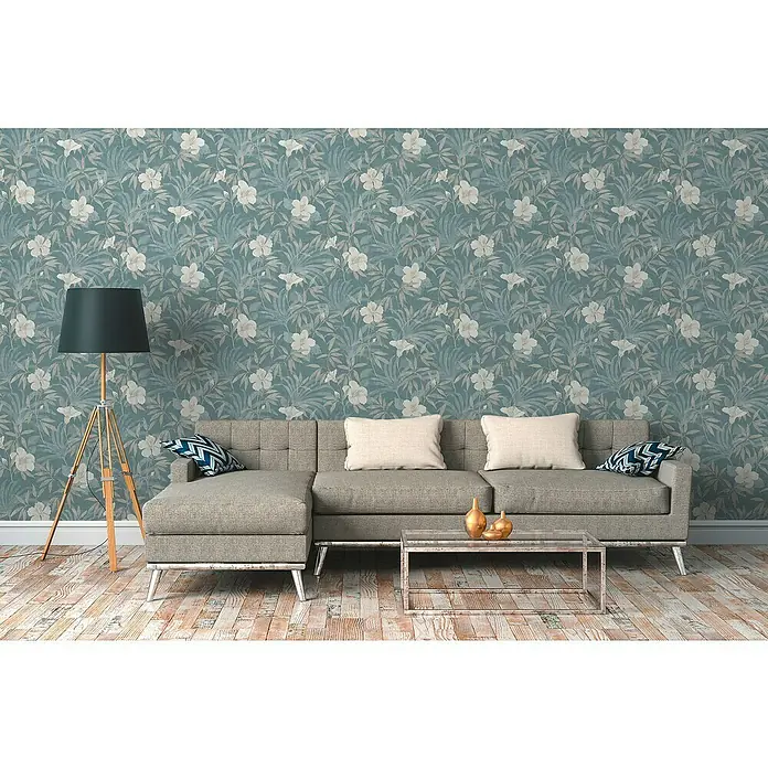 A.S. Création Cuba Vliestapete Blume - Beige/Blau, Floral, 10,05 x 0,53 m - Zimmeransicht mit einem grauen Sofa und einem Lampenständer vor einer floralen Tapete.