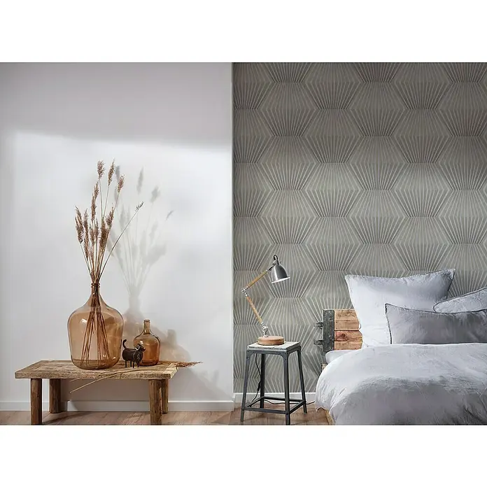 A.S. Création Titanium 3 Vliestapete 3D-Effekt Waben - Grau, 3D-Optik, 10,05 x 0,53 m - Elegantes Schlafzimmer mit einem bequemen Bett mit Kissen und einer Nachttischlampe. Das Zimmer ist mit einer stilvollen Vase und einem dekorativen Wandmuster versehen.