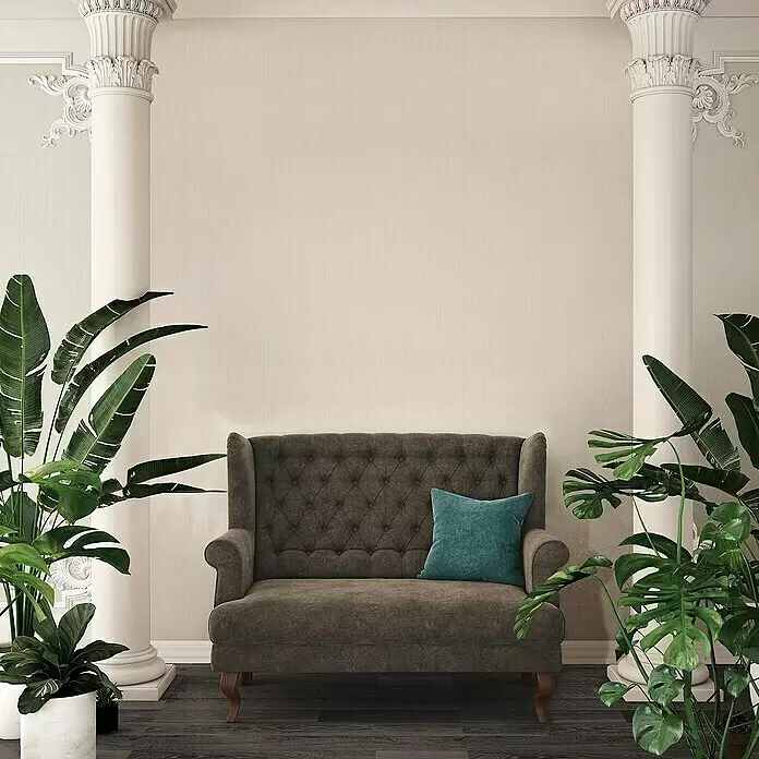 A.S. Création Attractive Vliestapete - Strukturcreme, Uni, 10,05 x 0,53 m - Dunkelgraues getuftetes Zweisitzer-Sofa mit türkisfarbenem Kissen in einem klassisch eingerichteten Wohnzimmer.