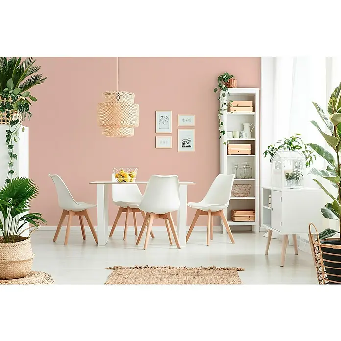 A.S. Création Trendwall 2 Vliestapete - Flamingo-Rosa, Uni, 10,05 x 0,53 m - Ein heller Essbereich mit einem Holztisch, weißen Stühlen und einer dekorativen Pendelleuchte, ergänzt durch Zimmerpflanzen und einem Bücherregal.