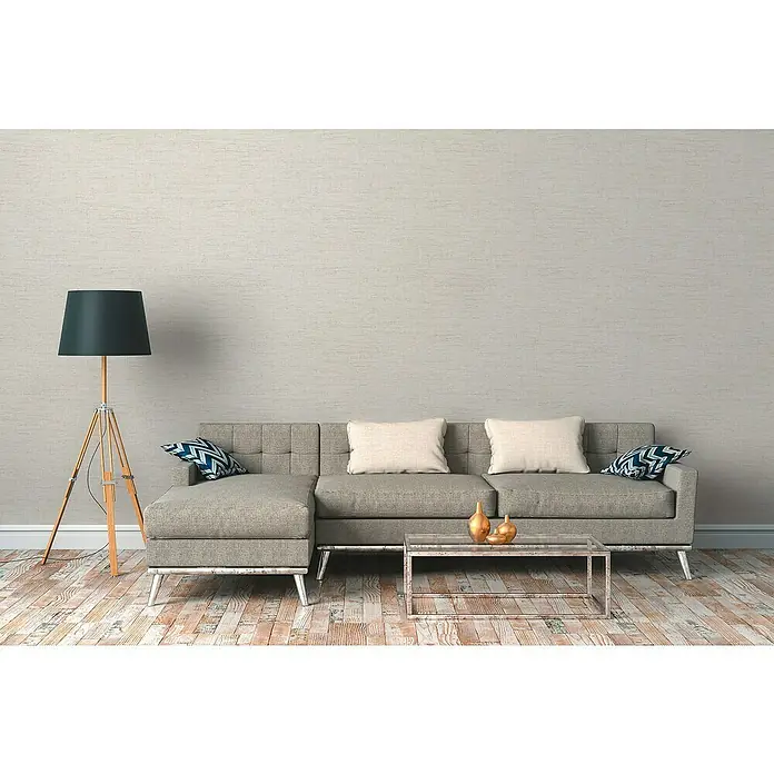 A.S. Création Desert Lodge Vliestapete GewebestrukturCreme, Uni, 10,05 x 0,53 m - Ein modernes Wohnzimmer mit einem grauen Sofa, Couchtisch, Stehlampe und dekorativen Kissen vor einer hellen Wand.