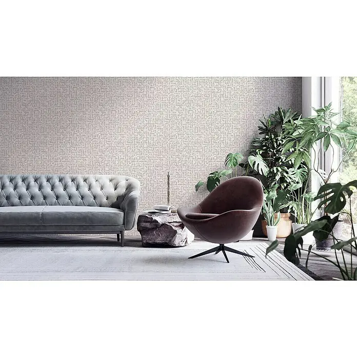 A.S. Création My Home My Spa Vliestapete Tetris - Weiß/Metallic, Grafisch, 10,05 x 0,53 m - Elegantes Wohnzimmer mit einem stilvollen grauen Sofa mit Knopfheftung, einem braunen Sessel und einer Vielzahl von Zimmerpflanzen.