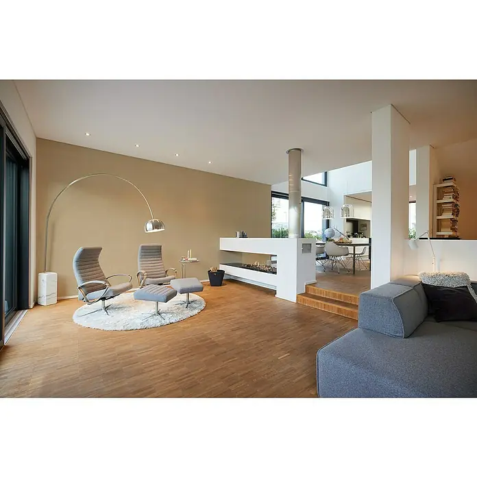 A.S. Création My Home My Spa Vliestapete - Beige/Metallic, Uni, 10,05 x 0,53 m - Helle Innenaufnahme mit Lounge-Sesseln, Bogenlampe und modernem Kamin. Die Einrichtung strahlt Eleganz und Komfort aus.