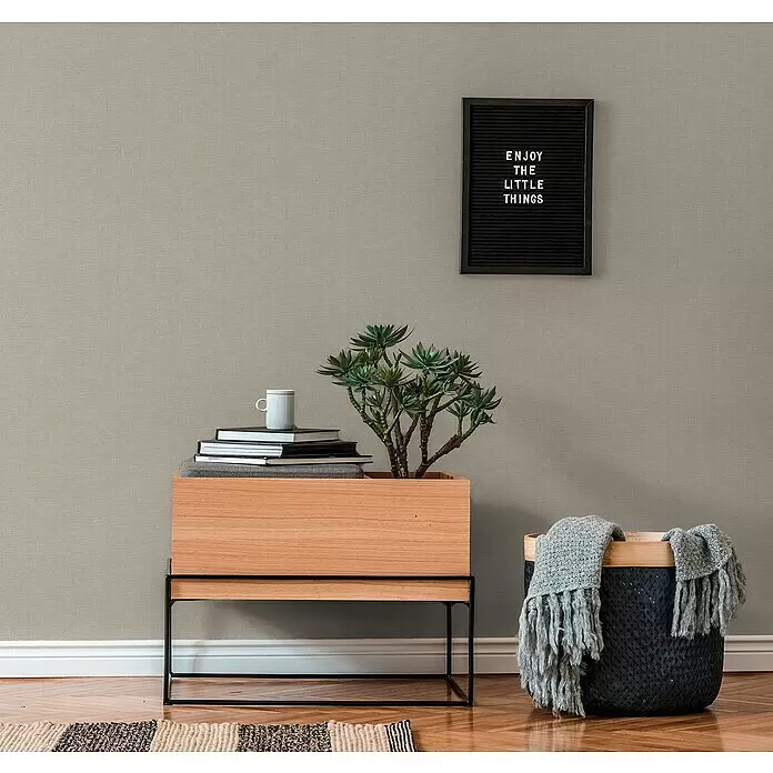 A.S. Création Hygge 2 Vliestapete Gewebe - Grau, Uni, 10,05 x 0,53 m - Dezente beigefarbene strukturierte Tapete an einer Wand in einem modernen Raum.