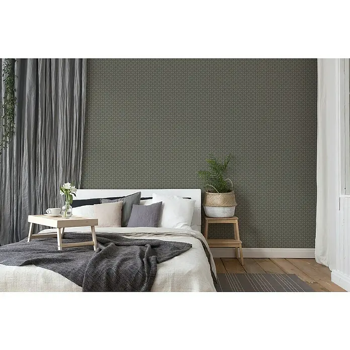 A.S. Création Trendwall 2 Vliestapete Art Deco groß - Grau, Grafisch, 10,05 x 0,53 m - Stilvolles Schlafzimmer mit gemütlichem Bett, grauem Tagesdecke und dekorativen Kissen vor einer dezent gemusterten Wand.