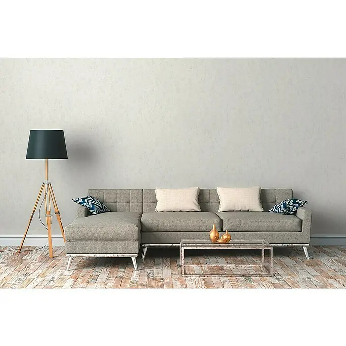 A.S. Création Hygge 2 Vliestapete - Creme, Uni, 10,05 x 0,53 m - Elegantes Wohnzimmer mit grauem Sofa, Stehlampe und Couchtisch. Die Einrichtung strahlt moderne Gemütlichkeit aus und lädt zum Verweilen ein.