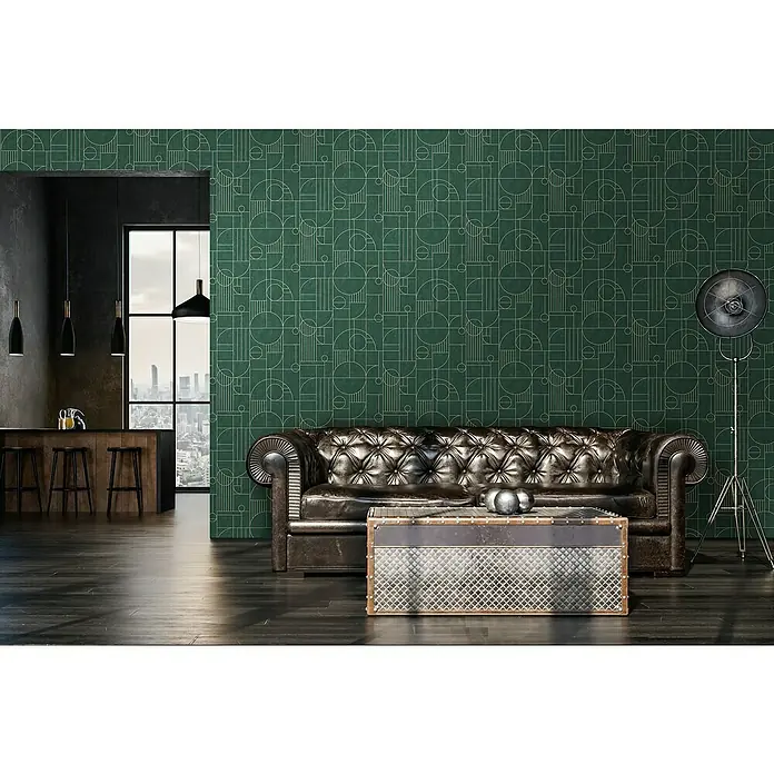 A.S. Création My Home My Spa Vliestapete Art Deco - Grün, Grafisch, 10,05 x 0,53 m - Ein stilvolles Wohnzimmer mit einem Chesterfield-Sofa, einem Couchtisch im Industriedesign und einer grünen Wand mit geometrischen Mustern.