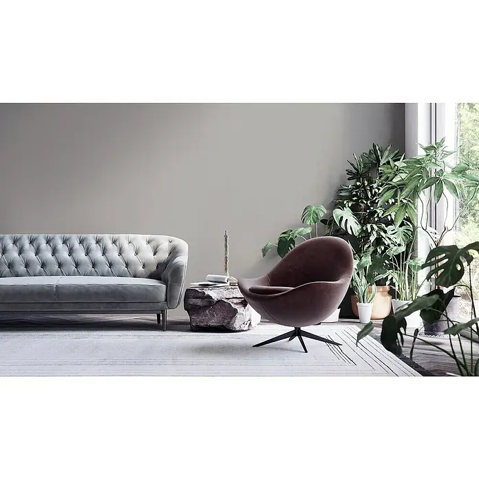 A.S. Création My Home My Spa Vliestapete Textstruktur I - Dunkelgrau, Uni, 10,05 x 0,53 m - Ein Wohnzimmer mit einem grauen Chesterfield Sofa und einem braunen Sessel. Dekorative Pflanzen vervollständigen das Bild.