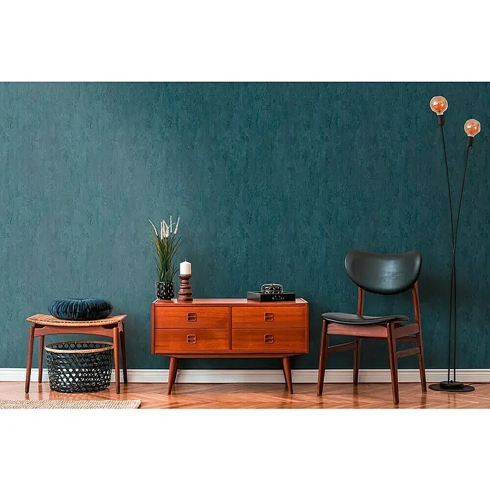 A.S. Création Trendwall 2 Vliestapete Rostoptik - Rost/Blau, Metalloptik, 10,05 x 0,53 m - Einrichten mit Stil: Kommode aus Holz, Stuhl und Stehlampe vor einer blauen Wand. Elegantes Design für ein gemütliches Zuhause.
