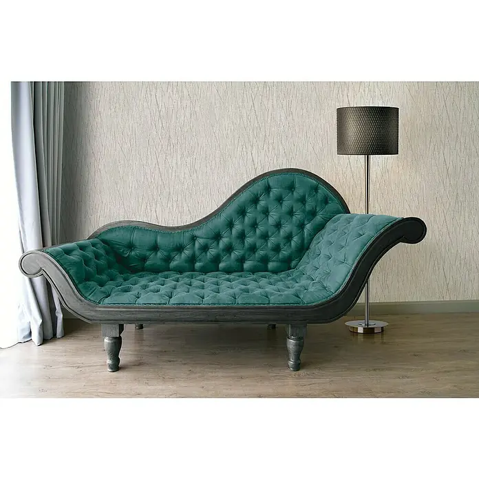 A.S. Création Hygge 2 Vliestapete Crush - Grau/Silber, Grafisch, 10,05 x 0,53 m - Elegante Chaiselongue mit smaragdgrüner Polsterung und dunklem Holzrahmen unter einer Stehlampe.