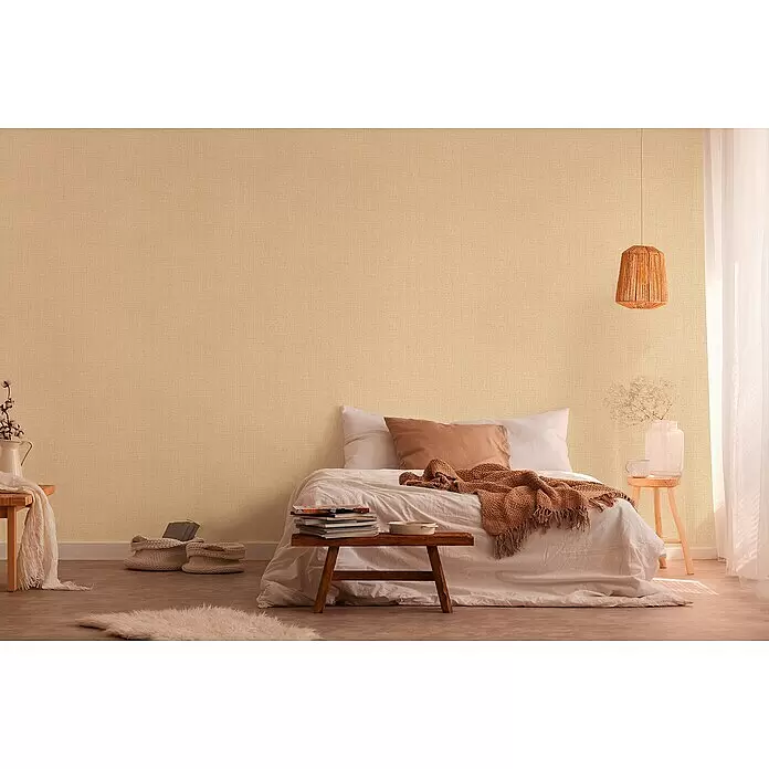 A.S. Création Desert Lodge Vliestapete - Beige/Gelb, Uni, 10,05 x 0,53 m, Feine Struktur - Strukturierte, hellbeige Tapete an einer Schlafzimmerwand, die eine warme und einladende Atmosphäre schafft.