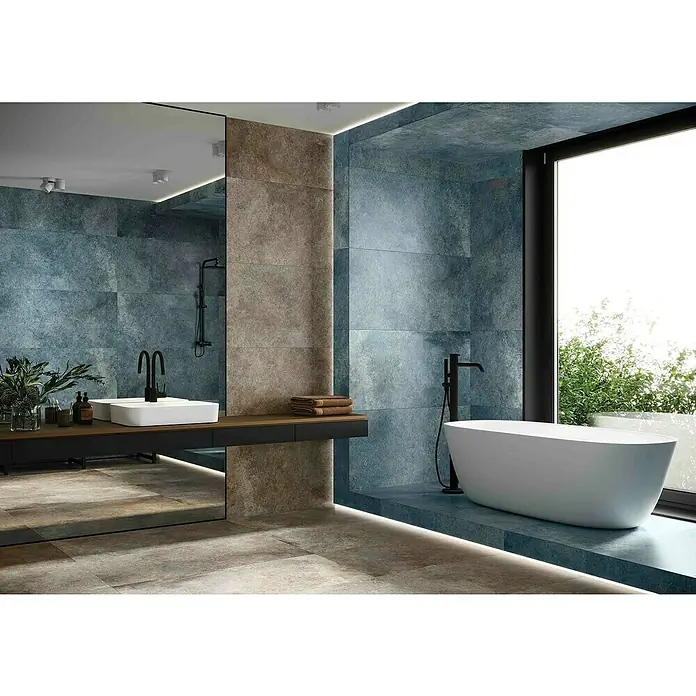 Feinsteinzeugfliese Blue Ocean - 59,7 x 119,7 cm, Blau, Matt - Das Bild zeigt ein elegantes Badezimmer mit einer freistehenden Badewanne, einem Waschtisch mit Aufsatzwaschbecken und stilvollen Armaturen.