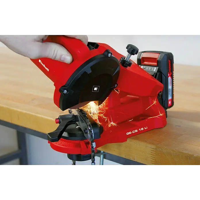 Einhell Power X-Change 18V Akku-Sägekettenschärfgerät GE-CS 18 Li-Solo - Mit LED-Beleuchtung, Schleifwinkeleinstellung, inklusive Schleifscheibe - Ein roter Kettenschärfer von Einhell, Modell GE-CS 18 Li, der eine Kettensäge schärft und Funken sprühen lässt.\n