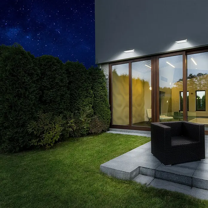 Arte confort Aplique solar para exterior con sensor Vegas - 8,1 W, L x An x Al: 30,5 x 10,5 x 8 cm, Plateado - Iluminación moderna de patio con luces LED para exteriores que crean un ambiente acogedor. El sillón oscuro invita a relajarse al aire libre.