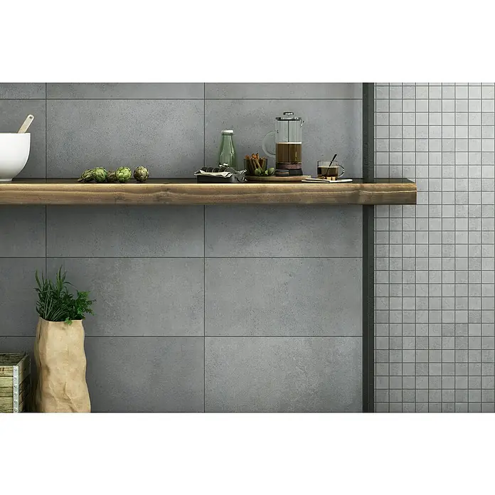 Art-Tec by Palazzo Feinsteinzeugfliese - 30 x 60 cm, Steel, Matt - Einrichtung mit einer Holzablage an einer grauen Wand, auf der eine Kaffeepresse, Artischocken und Kräuter stehen, die eine gemütliche Atmosphäre schaffen.