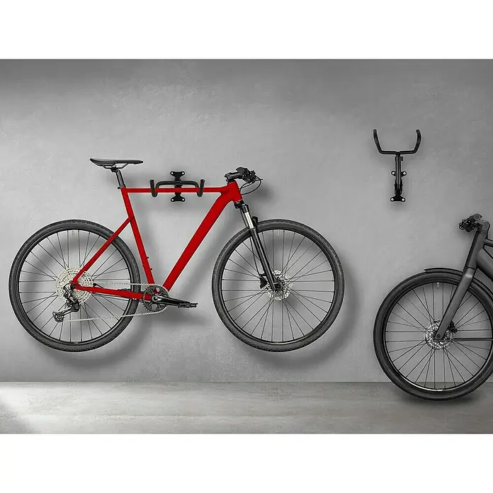 LAS Fahrradhalterung - Traglast: 30 kg, 1 Stk. - Eine rote Mountainbike hängt an einer Fahrradhalterung an der Wand, daneben eine weitere Halterung und ein Teil eines schwarzen Fahrrads.