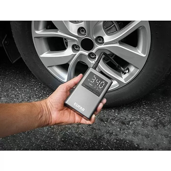 Eufab Kompressor - 12 V - Grauer digitaler Reifenfüller, von einer Hand gehalten und an ein Autoreifenventil angeschlossen, zeigt 3,40 Bar und ein Ziel von 3,50 Bar an.
