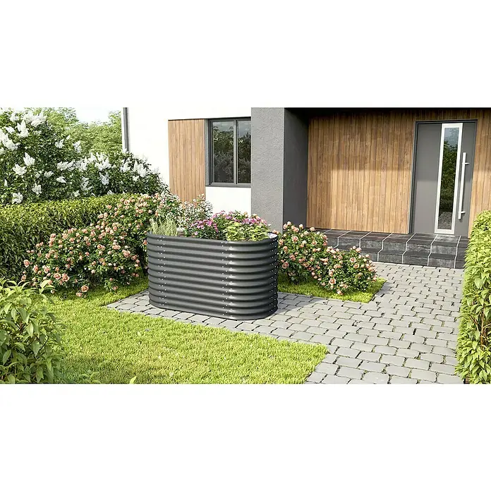 Vitavia Hochbeet Terra 858 - 162 x 82 x 85,8 cm, Zincalume®, Granit - Ein graues Hochbeet aus Metall steht vor einem Haus, umgeben von Blumen und Grünpflanzen. Ideal für Gartenliebhaber, die Wert auf Design legen.