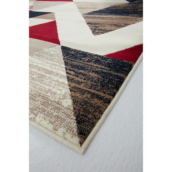 Alfombra de pelo corto Alpes - Granate, 100% polipropileno - Detalle de una alfombra moderna con un diseño geométrico en rojo, beige, blanco y negro, que muestra su elegante patrón.