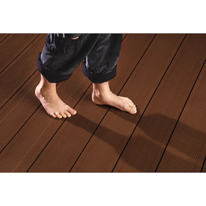 Kovalex WPC-Terrassenpaket Exklusiv - Braun, 3 x 3 m - Barfuß auf einer braunen Terrassendiele aus robustem WPC-Material. Ideal für den Außenbereich, langlebig und pflegeleicht.