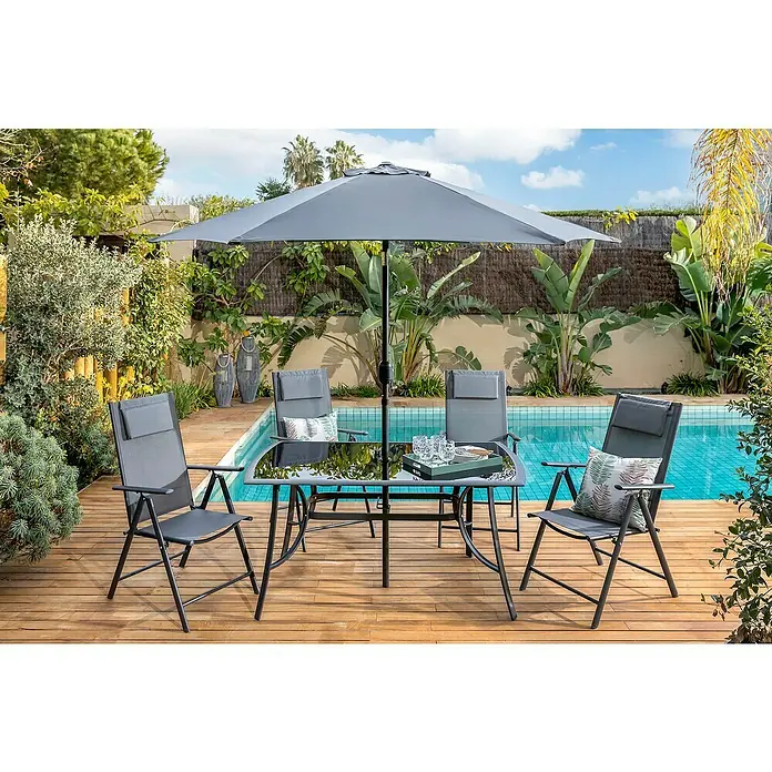 Sillón de posiciones Donavan - An x Pr x Al: 72 x 55 x 107 cm, Antracita - Un conjunto de jardín gris con mesa, sillas y sombrilla en una terraza de madera junto a una piscina, perfecto para relajarse al aire libre.