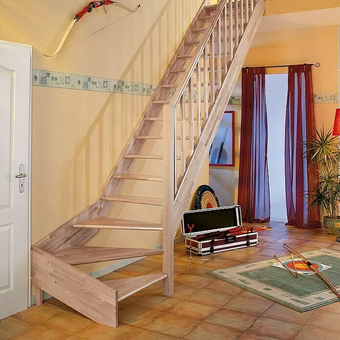 Dolle Raumspartreppe Paris - Breite: 83,5 mm, Buche, Unbehandelt, Geschosshöhe: 318 cm, 1/4-gewendelt rechts, Rechteckstäbe Holz, Ohne Setzstufen - Eine kompakte Treppe aus hellem Naturholz mit Geländer, die in einem Wohnambiente nach oben führt. Ideal für kleine Räume.