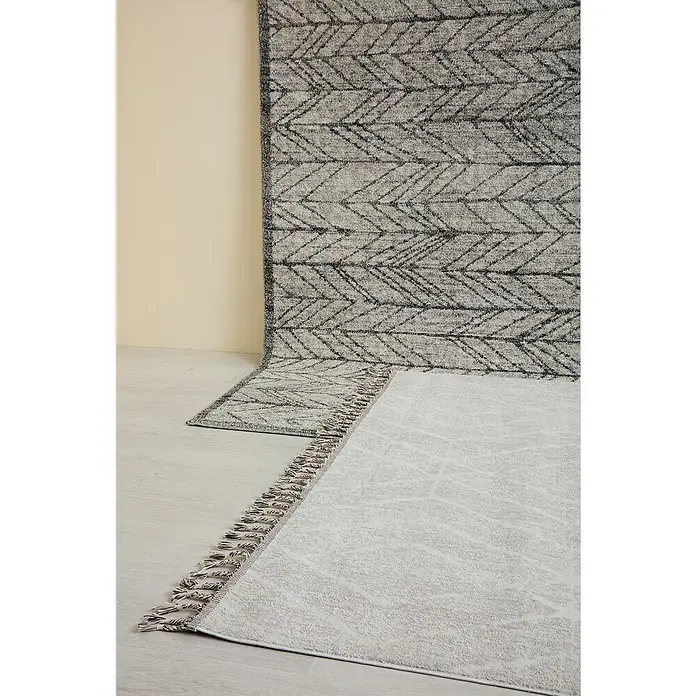 Alfombra de pelo corto Claudia Rombos - Crema, 60 x 110 cm, 100% poliéster - Alfombras grises con diferentes estampados, una con flecos, sobre una pared beige para un ambiente acogedor.