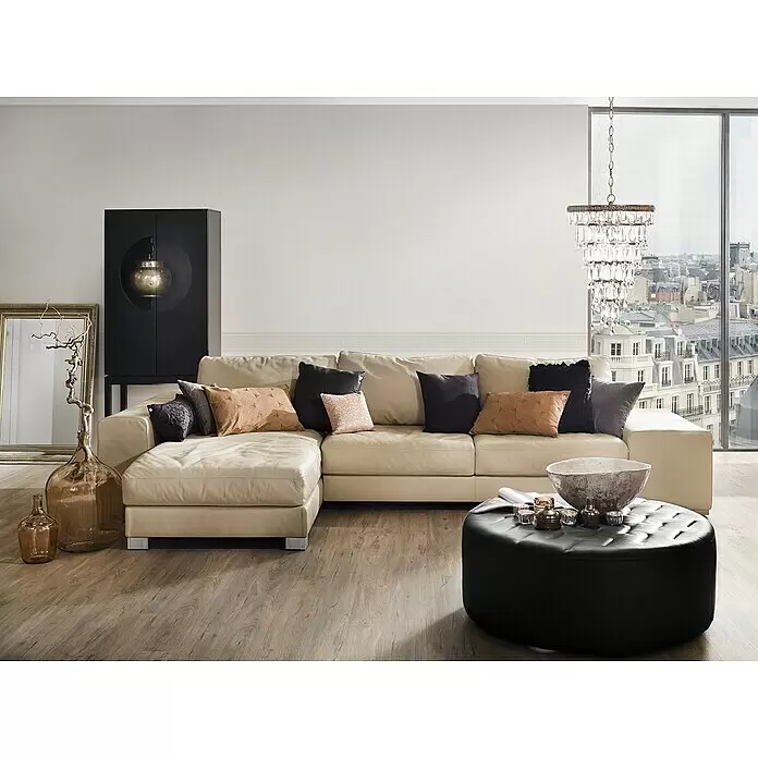 A.S. Création Only Borders 11 Tapetenborte Mäander - Weiß, 5 x 0,13 m, Selbstklebefolie - Beiges Leder-Ecksofa mit verschiedenen Kissen in einem modernen Wohnzimmer.