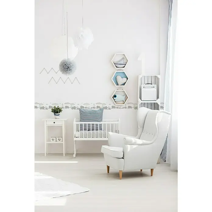 A.S. Création Only Borders 11 Tapetenborte Elefanten - Kunststoff, Grau/Weiß - Helles Kinderzimmer mit weißem Schaukelstuhl, Babybett und Nachttisch. Dekorative Details wie Wandbordüren und Papierpompons verleihen dem Raum eine verspielte Note.