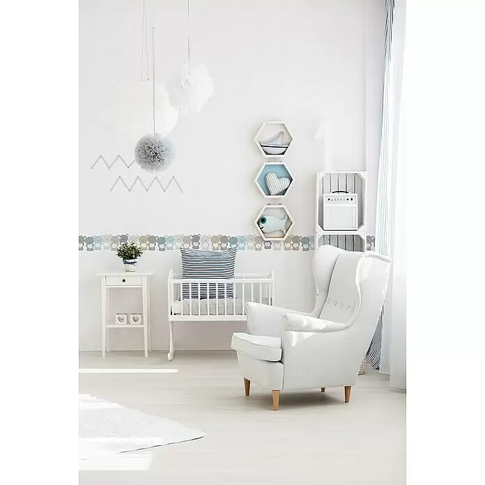 A.S. Création Lovely Kids Tapetenborte - Kunststoff, Bärchen Beige-Blau - Helles, ruhiges weißes Kinderzimmer mit Gitterbett, Sessel, Deko-Regalen und dezenter Wandkunst für einen gemütlichen, modernen Babybereich.