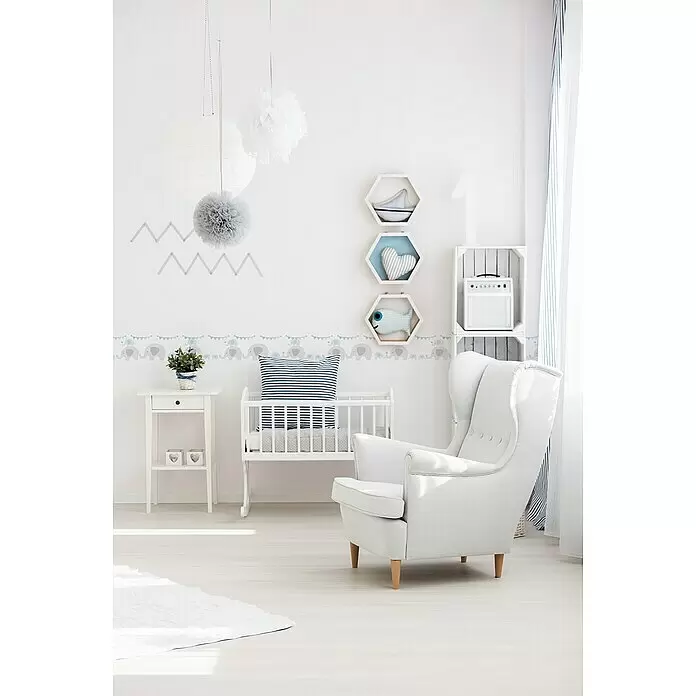 A.S. Création Only Borders 11 Tapetenborte Elefanten - Kunststoff, Blau/Grau - Weißes Holzbettchen und hellgrauer Stoff-Sessel in einem hellen Babyzimmer mit Dekorationselementen.