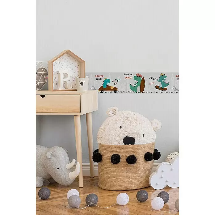 A.S. Création Lovely Kids Tapetenborte - Kunststoff, Dinos - Dino-Wandbordüre mit fahrenden, surfenden und skateboardfahrenden Cartoon-Dinos vor grauer Stadtsilhouette im Kinderzimmer.