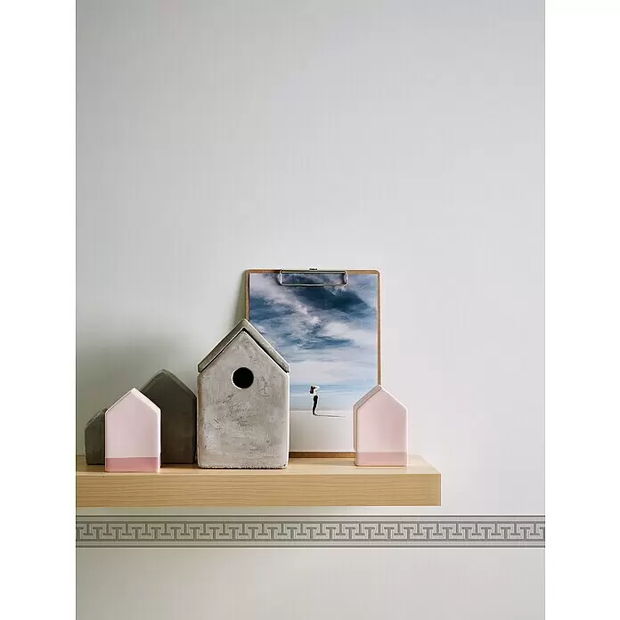 A.S. Création Only Borders 11 Tapetenborte Mäander - L x B: 5 m x 4 cm, Kunststoff, Grau/Silber - Dekorative hausförmige Objekte aus Beton und Rosa auf einem Holzregal, mit einem Landschaftsbild und einer griechischen Musterbordüre.