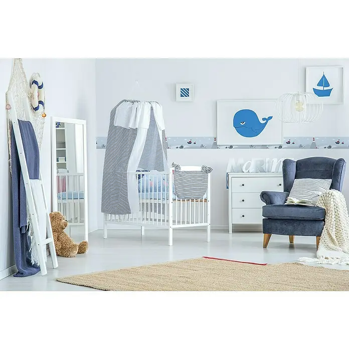 A.S. Création Only Borders 11 Tapetenborte Meerestreiben - Kunststoff, Blau - Bild von einem Babyzimmer mit einem weißen Kinderbett mit blau-weiß gestreiftem Überhang und maritimen Dekorationen.