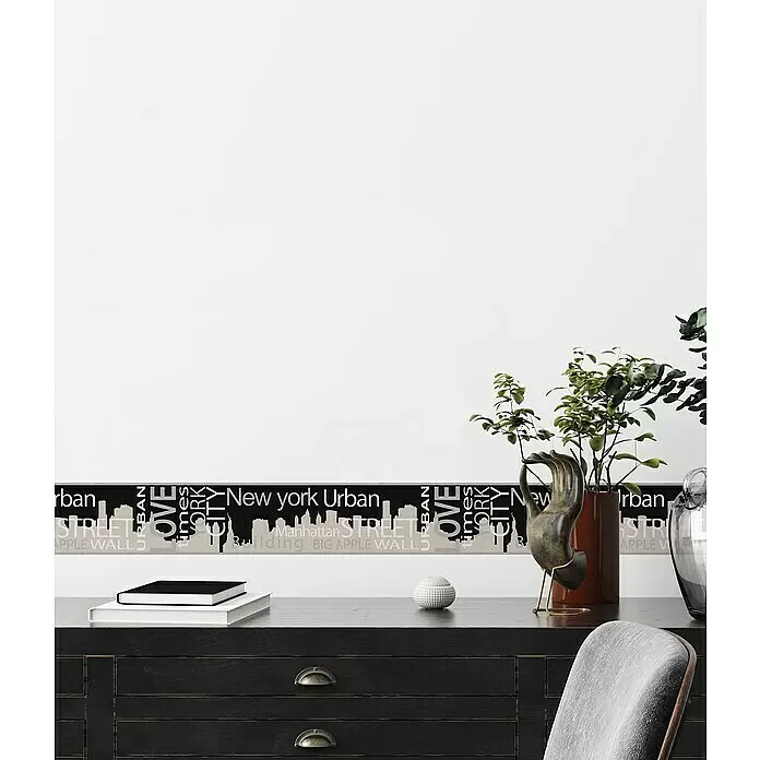 A.S. Création Only Borders 11 Tapetenborte Skyline - Kunststoff, Schwarz/Weiß - Dekorative Wandbordüre mit schwarzem und beigem New York City-Skyline- und Textdesign, auf einer weißen Wand über einem dunklen Holzschreibtisch.