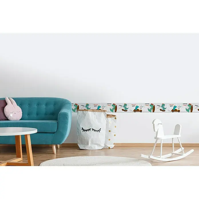 A.S. Création Lovely Kids Tapetenborte - Kunststoff, Dinos - Ein Kinderzimmer mit einer Bordüre mit Dinosauriern, einem türkisfarbenen Sofa, einem Tisch, einem Spielzeugpferd und Aufbewahrungssäcken.