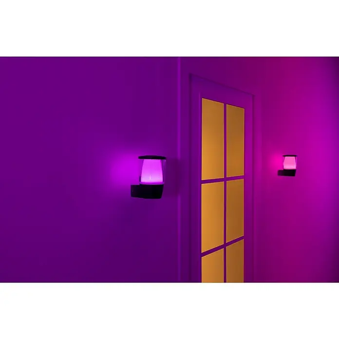 Philips Wiz LED-Außenwandleuchte Elpas - 8,5 W, 13,4 x 10,9 x 16,4 cm, IP44, RGBW - Nahaufnahme von zwei lila leuchtenden Philips Hue Wandleuchten mit einem modernen Design an einer Wand neben einer Tür.