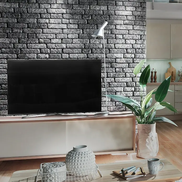 Panel de pared Loft - 2 ud., 120 x 50 cm, Antracita - Primer plano de una sala de estar moderna con un televisor grande, una lámpara de pie y objetos decorativos en una mesa de centro.